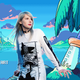Christine Love stands superimposed in front of her game's start screen which has pixel art of boat cruising on a lake and a sword at the bed of a palm tree.